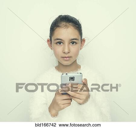 Stock Image - Mixed race girl using cell phone. Fotosearch