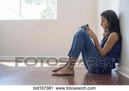 Mixed race girl using digital tablet in empty room View Large Photo Image Stock Image - Mixed race girl using digital tablet in empty room. Fotosearch