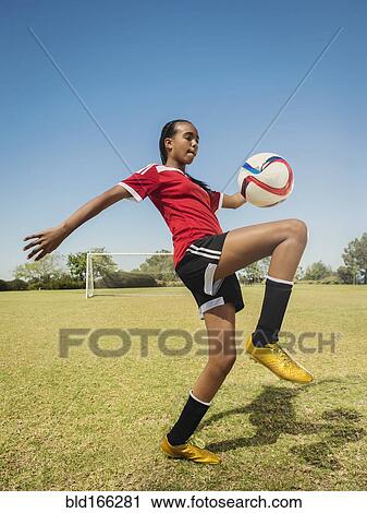 Mixed race soccer player kicking ball on field View Large Photo Image Stock Image - Mixed race soccer player kicking ball on field. Fotosearch