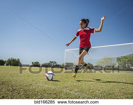Mixed race soccer player kicking ball on field View Large Photo Image Stock Photography - Mixed race soccer player kicking ball on field. Fotosearch