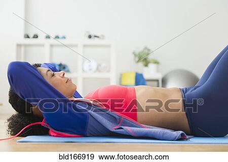 Mixed race woman doing sit-ups in gym View Large Photo Image Stock Photo - Mixed race woman doing sit-ups in gym. Fotosearch