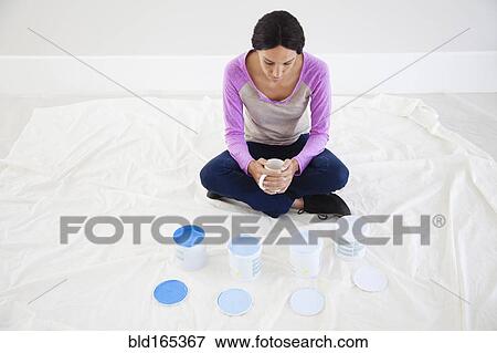Mixed race woman examining paint samples in new home View Large Photo Image Stock Photo - Mixed race woman examining paint samples in new home. Fotosearch