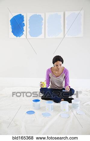 Mixed race woman examining paint samples in new home View Large Photo Image Stock Photo - Mixed race woman examining paint samples in new home. Fotosearch
