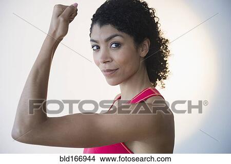 Mixed race woman flexing muscles View Large Photo Image Picture - Mixed race woman flexing muscles. Fotosearch