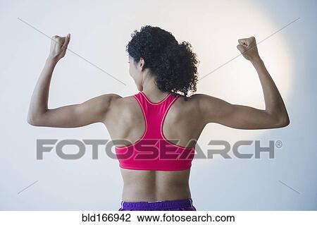 Mixed race woman flexing muscles View Large Photo Image Stock Image - Mixed race woman flexing muscles. Fotosearch