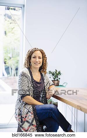 Mixed race woman sitting at counter View Large Photo Image Stock Photography - Mixed race woman sitting at counter. Fotosearch
