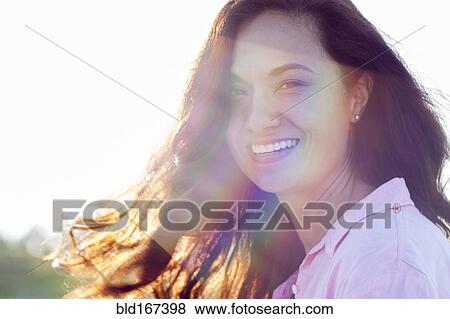 Stock Photo - Mixed race woman smiling outdoors. Fotosearch