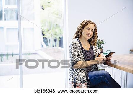 Mixed race woman using digital tablet at counter View Large Photo Image Stock Photograph - Mixed race woman using digital tablet at counter. Fotosearch