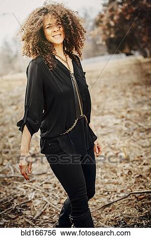 Stock Photograph - Mixed race woman walking in field. Fotosearch