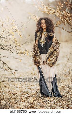 Stock Image - Mixed race woman wearing stylish clothes in field. Fotosearch