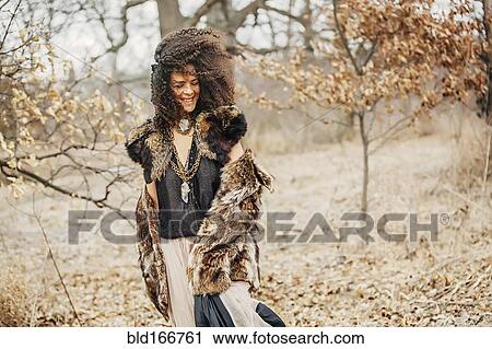 Stock Image - Mixed race woman wearing stylish clothes in field. Fotosearch