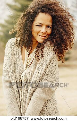 Stock Photo - Mixed race woman wearing stylish sweater. Fotosearch
