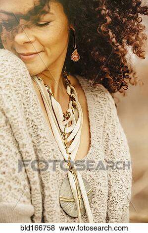 Stock Photo - Mixed race woman wearing stylish sweater. Fotosearch