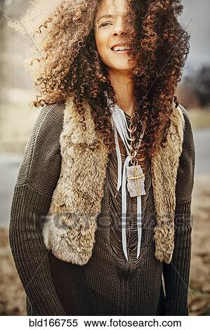 Stock Photography - Mixed race woman wearing stylish vest outdoors. Fotosearch
