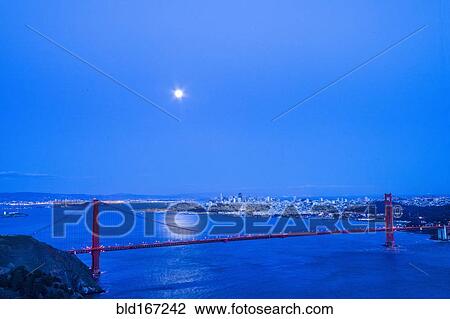 Stock Image - Moon in night sky over Golden Gate Bridge, San Francisco, California, United States. Fotosearch