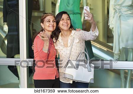 Mother and daughter taking selfie outside store View Large Photo Image Stock Photo - Mother and daughter taking selfie outside store. Fotosearch