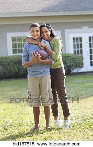 Mother and son hugging in backyard View Large Photo Image Stock Photography - Mother and son hugging in backyard. Fotosearch