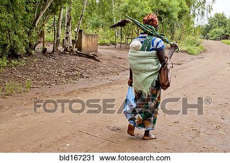 Mother carrying baby with traditional wrap on dirt road View Large Photo Image Stock Image - Mother carrying baby with traditional wrap on dirt road. Fotosearch