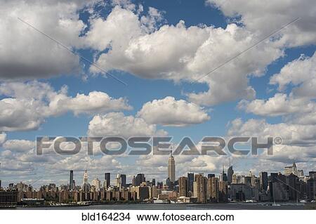 Picture - New York City skyline under cloudy blue sky, New York, United States. Fotosearch