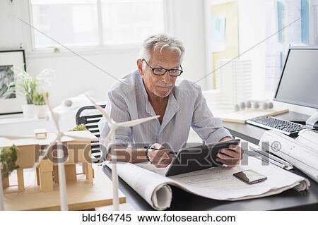 Older Caucasian architect using digital tablet in office View Large Photo Image Stock Photography - Older Caucasian architect using digital tablet in office. Fotosearch