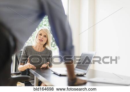 Stock Photo - Older Caucasian business people arguing in office meeting. Fotosearch