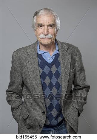 Stock Photography - Older Caucasian man standing with hands in pockets. Fotosearch