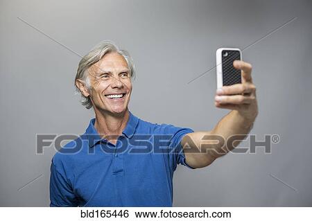 Stock Photograph - Older Caucasian man taking selfie. Fotosearch
