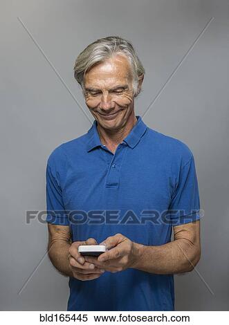 Stock Photography - Older Caucasian man using cell phone. Fotosearch