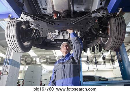 Older Hispanic mechanic repairing car in garage View Large Photo Image Stock Image - Older Hispanic mechanic repairing car in garage. Fotosearch