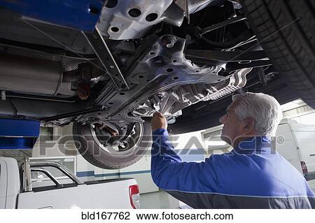 Older Hispanic mechanic repairing car in garage View Large Photo Image Stock Image - Older Hispanic mechanic repairing car in garage. Fotosearch