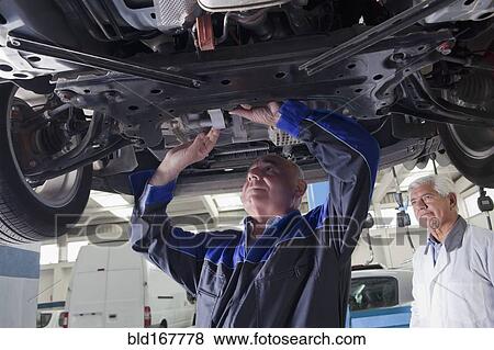 Older Hispanic mechanic repairing car in garage View Large Photo Image Stock Photo - Older Hispanic mechanic repairing car in garage. Fotosearch