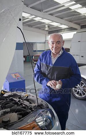 Older Hispanic mechanic working on car in garage View Large Photo Image Stock Photography - Older Hispanic mechanic working on car in garage. Fotosearch