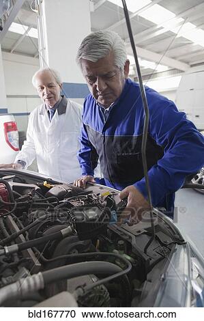Older Hispanic mechanics repairing car in garage View Large Photo Image Stock Image - Older Hispanic mechanics repairing car in garage. Fotosearch