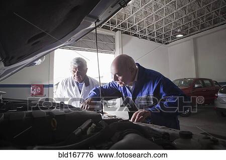 Older Hispanic mechanics repairing car in garage View Large Photo Image Stock Photograph - Older Hispanic mechanics repairing car in garage. Fotosearch