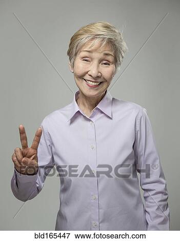 Older Japanese woman making peace sign View Large Photo Image Stock Photo - Older Japanese woman making peace sign. Fotosearch