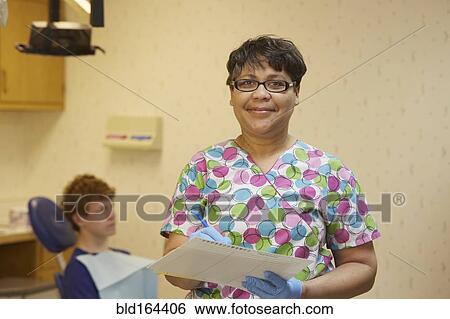 Pediatric dentist smiling in office View Large Photo Image Stock Photograph - Pediatric dentist smiling in office. Fotosearch