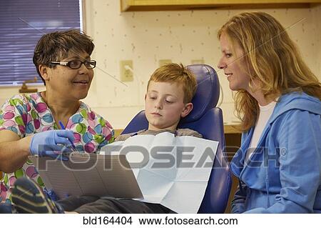 Pediatric dentist talking to patient and mother View Large Photo Image Picture - Pediatric dentist talking to patient and mother. Fotosearch