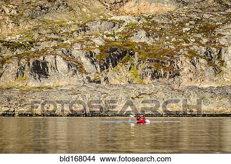 People paddling canoe near rock formations in remote river View Large Photo Image Picture - People paddling canoe near rock formations in remote river. Fotosearch