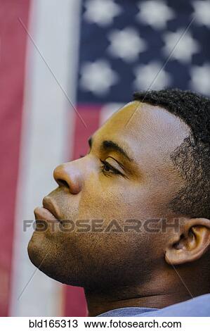 Stock Image - Profile of Black man in front of American flag. Fotosearch