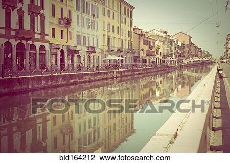 Stock Image - Reflections of buildings in canal, Milano, Lombardi, Italy. Fotosearch