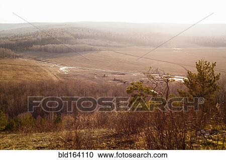 Stock Image - Rolling hills and fields in rural landscape. Fotosearch