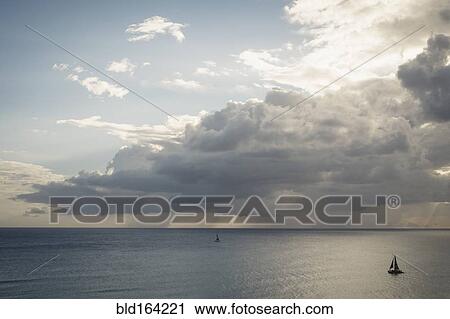 Sailboats under clouds on ocean View Large Photo Image Stock Image - Sailboats under clouds on ocean. Fotosearch
