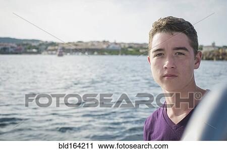 Stock Image - Serious Caucasian boy on boat. Fotosearch