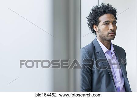 Serious Hispanic businessman at office window View Large Photo Image Stock Image - Serious Hispanic businessman at office window. Fotosearch