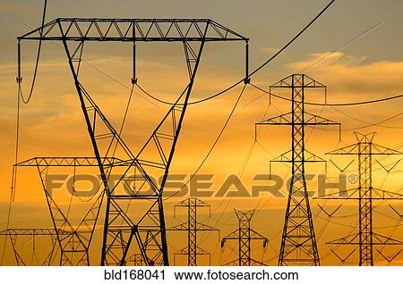 Stock Image - Silhouette of power lines under sunset sky. Fotosearch