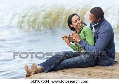 Smiling couple hugging at dock View Large Photo Image Picture - Smiling couple hugging at dock. Fotosearch