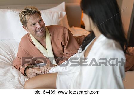 Stock Photo - Smiling couple relaxing on bed. Fotosearch