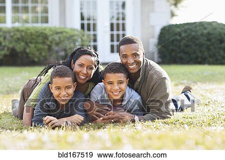 Stock Photo - Smiling family playing in backyard. Fotosearch