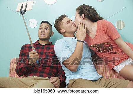 Stock Image - Smiling friends taking selfie together. Fotosearch