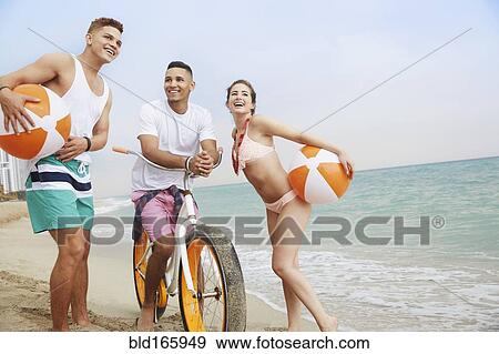 Smiling friends talking on beach View Large Photo Image Stock Photo - Smiling friends talking on beach. Fotosearch